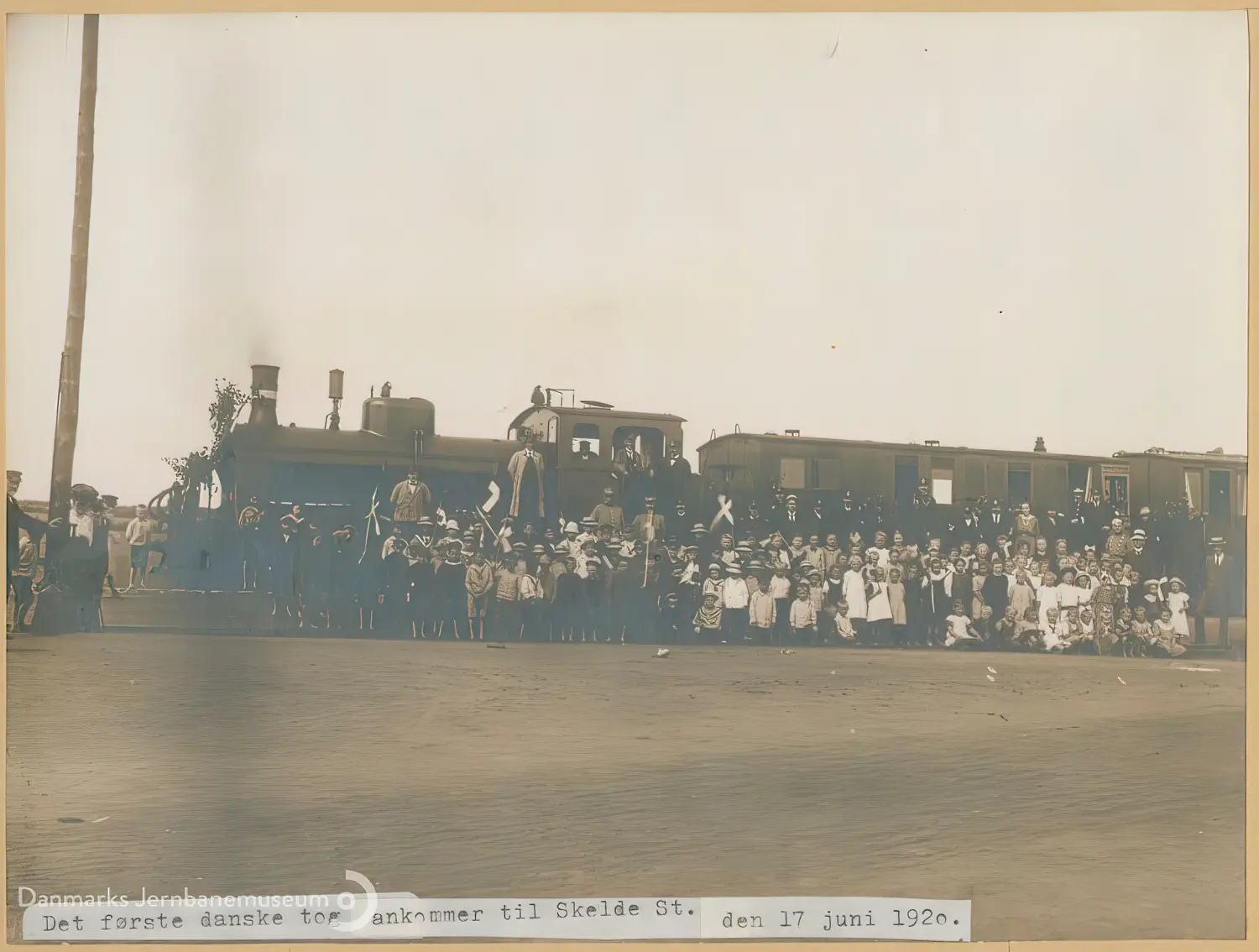 Billede af det første danske tog er ankommet til Skelde Station og publikum flokkes ved toget.