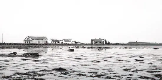 Knudshoved omkring 1899 set fra vest med stationsbygningen til venstre og remisen til højre. Det tidligere fyr ses også. Det nuværende fyrtårn er fra 1948 og noget højere. Til gengæld er fyrbakken blevet mindre. Sporet fortsætter mod Slipshavn
