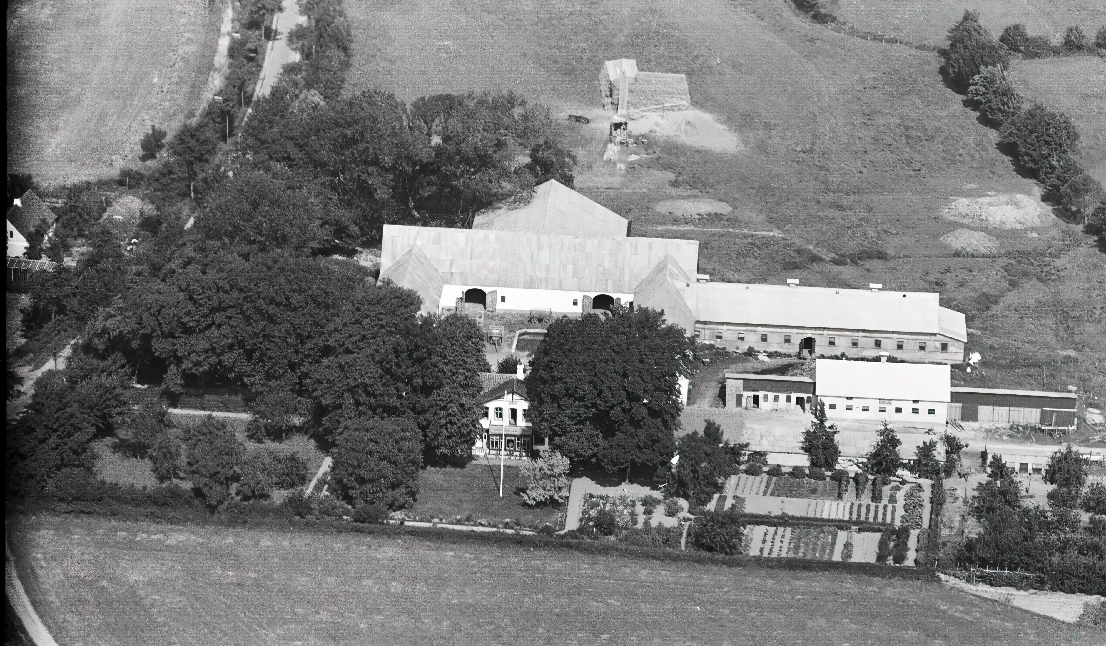 Billede af Sillerupgård Trinbræt, som har ligget ved Sillerupgård ud for det hvide hus, som lige kan anes i venstre side af billedet.