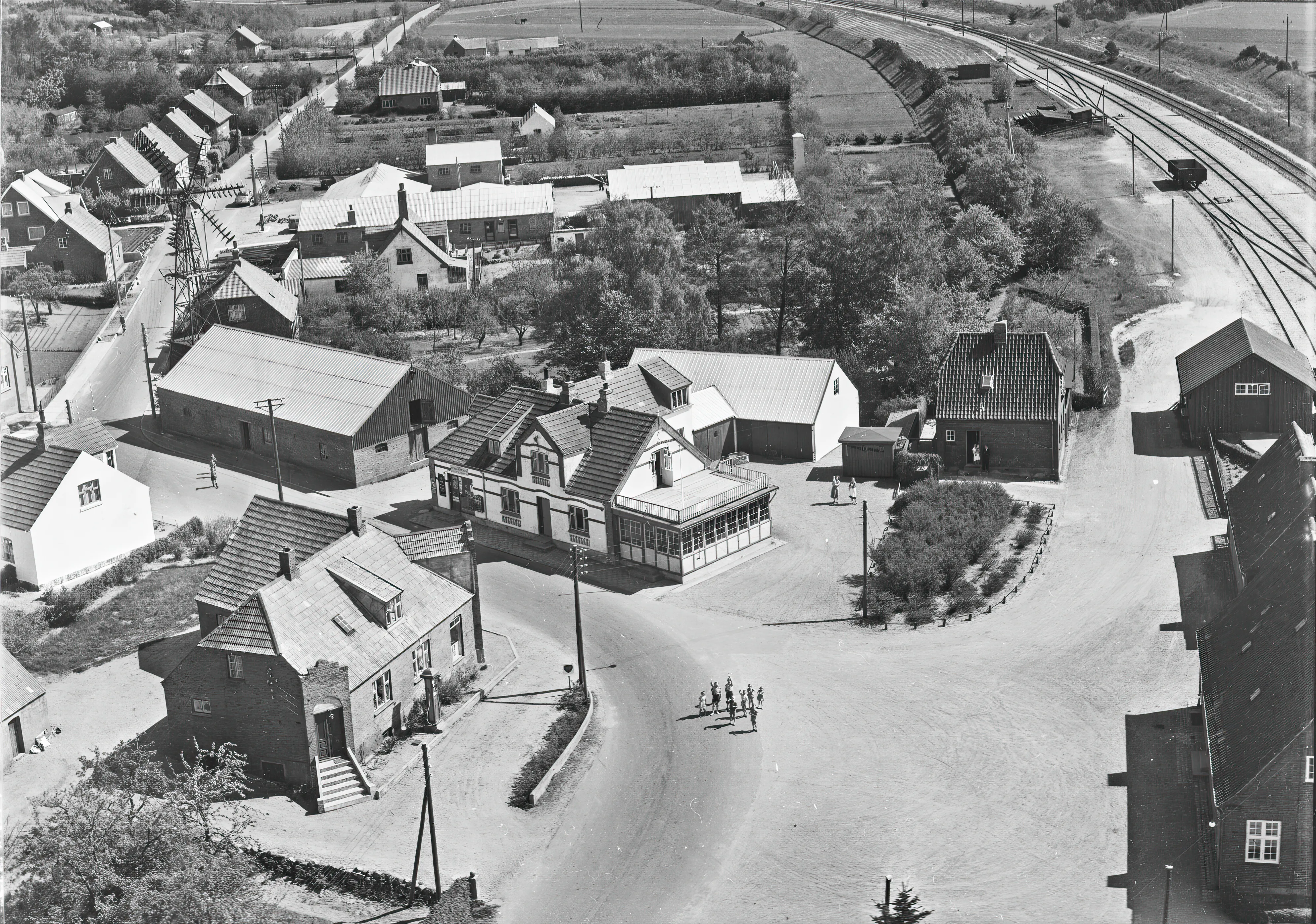 Billede af Tange Billetsalgssted til venstre for stationen med et par stående og kikke i døråbningen.