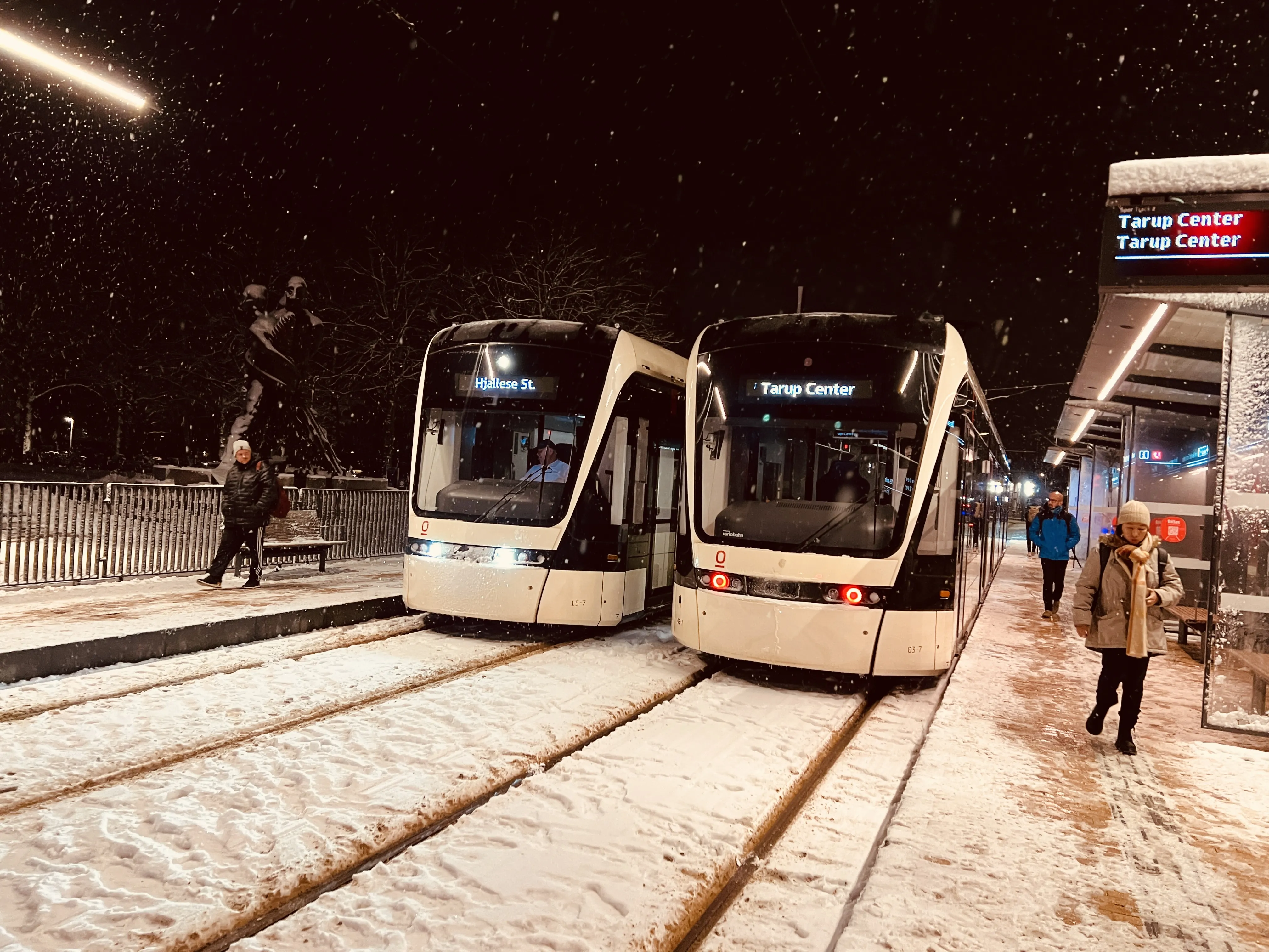 Billede af Odense Letbane togsæt 03 holdende ved togsæt 15, fotograferet ud for Odense Banegård Letbanestation.