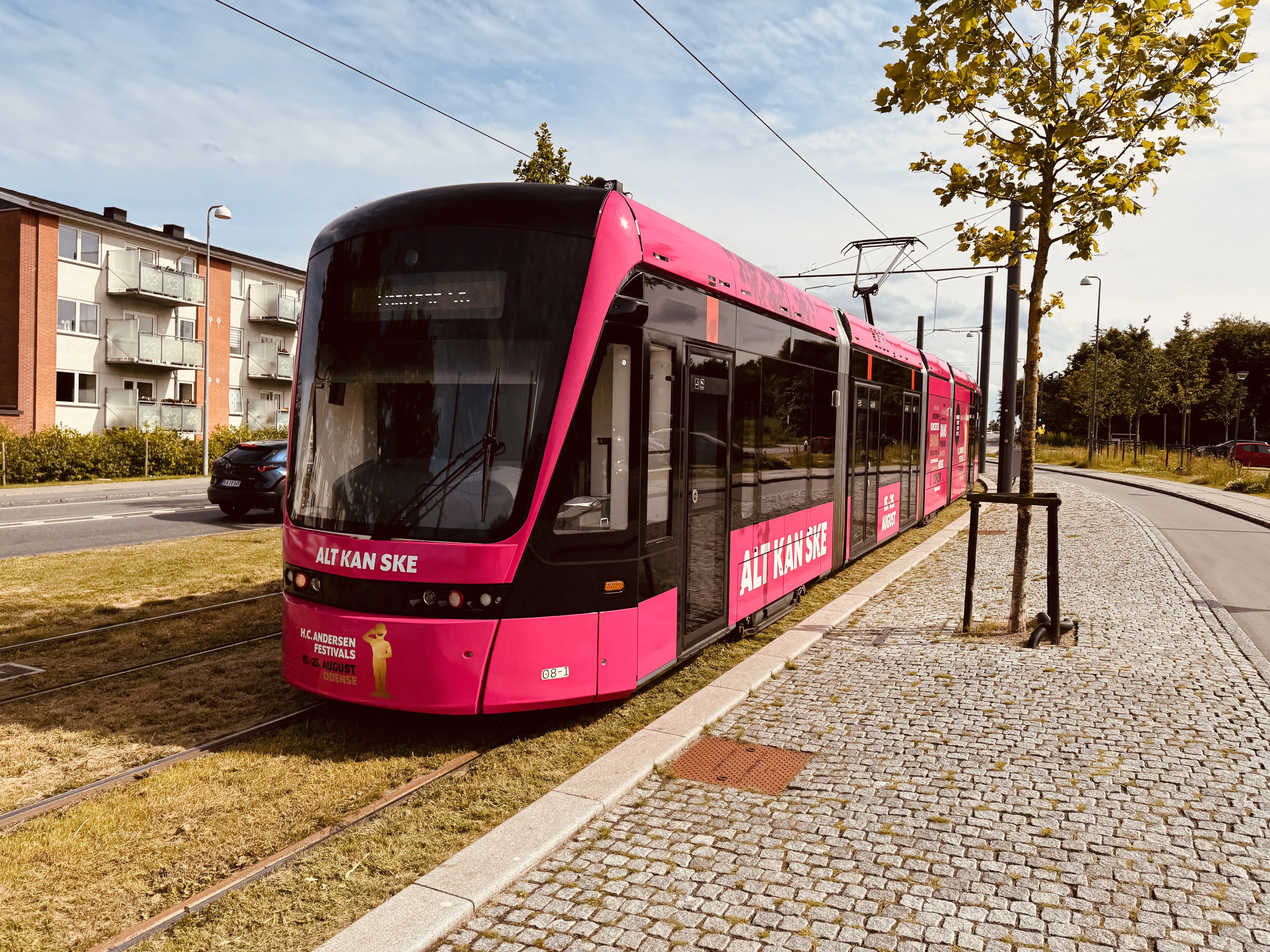 Billede af Odense Letbane togsæt 08, i H.C. Andersen Festivals udklædning, fotograferet ud for Højstrup Letbanestation.