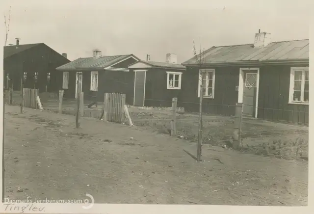 Billede af midlertidige boliger for jernbanefolk til Tinglev Station efter Genforeningen. Svellehuse på Birkeallé, set mod øst. I baggrunden tv. lokomotivremisen.