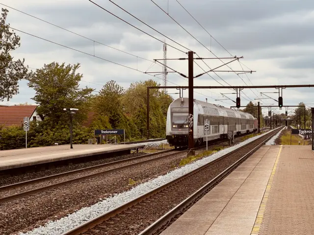 Billede af tog ud for Trekroner Station.