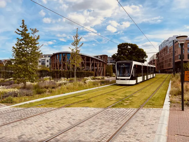 Billede af letbanetog ud for H. C. Andersens Museum og på vej ind på Odeon Letbanestation.