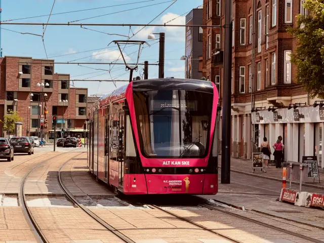 Billede af Odense Letbane togsæt 15 i HCA Festivalsforklædning fotograferet ud for Odense Banegård Letbanestation.
