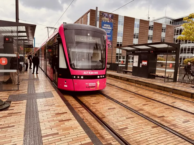 Billede af Odense Letbane togsæt 12 i HCA Festivalsforklædning fotograferet ud for Odense Banegård Letbanestation.