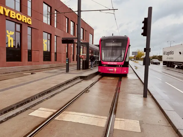 Billede af Odense Letbane togsæt 12 i HCA Festivalsforklædning fotograferet ud for Tarup Center Letbanestation.