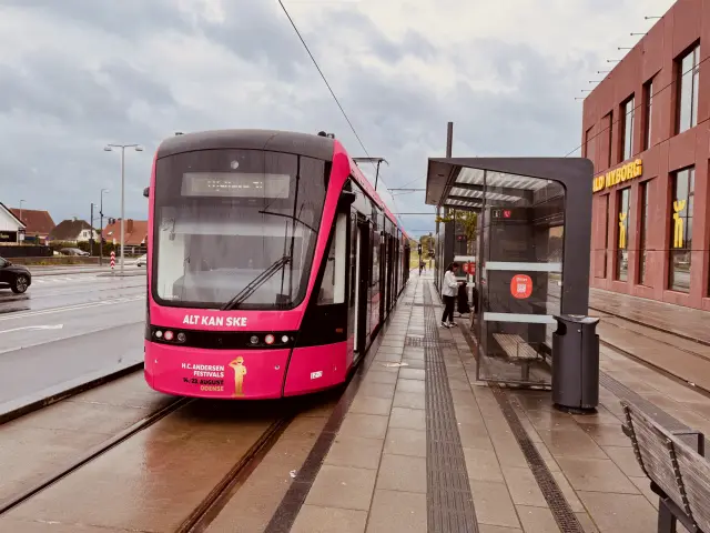 Billede af Odense Letbane togsæt 12 i HCA Festivalsforklædning fotograferet ud for Tarup Center Letbanestation.