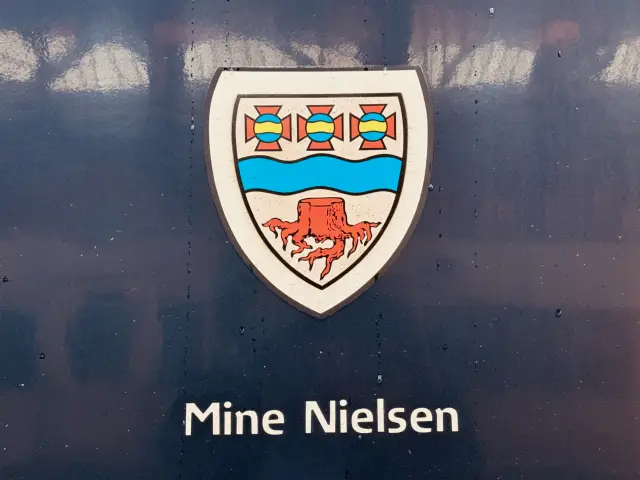 Billede af Langaas byvåben og navngivet "Mine Nielsen" på siden af DSB MF 5002 fotograferet ud for København Hovedbanegård.